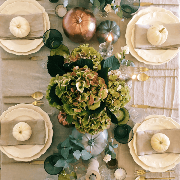 Top view of table settings with flowers and pumpkins.