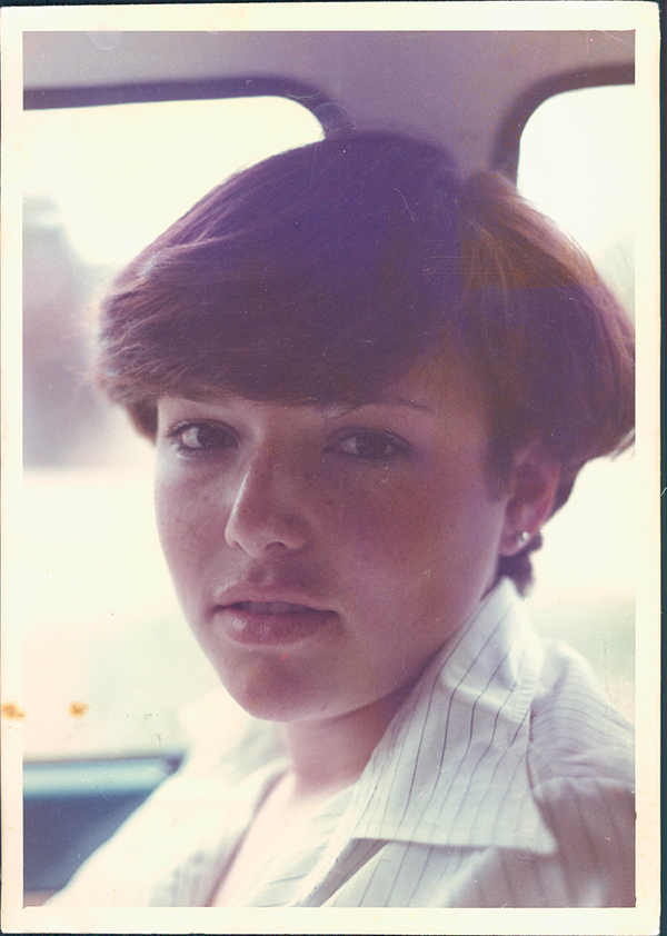 Female with short brown hair and white striped shirt.
