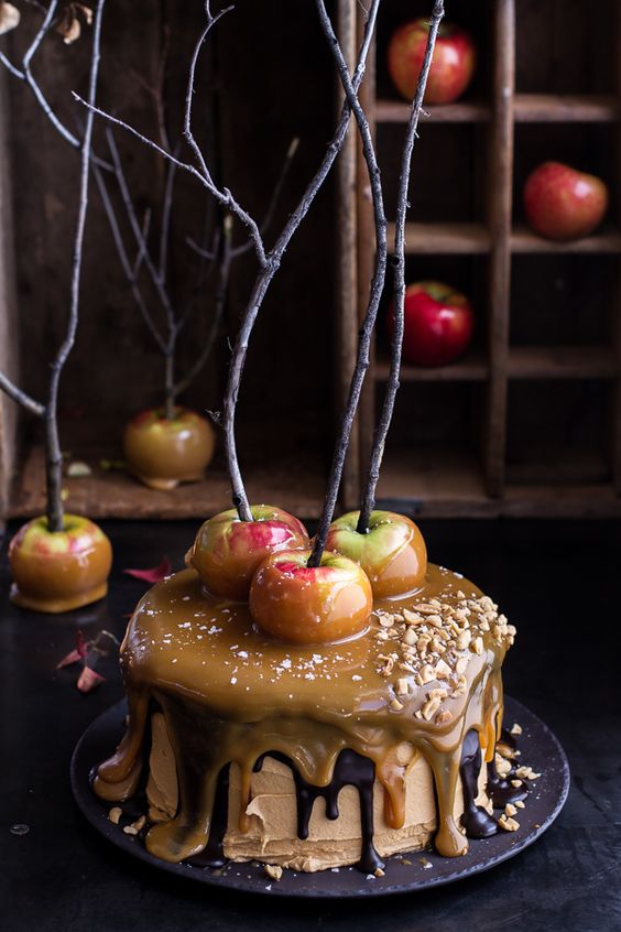 Frosted cake topped with apples and branches. 