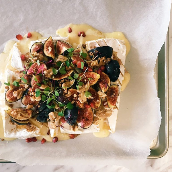 Top view of baked brie with mixed toppings. 