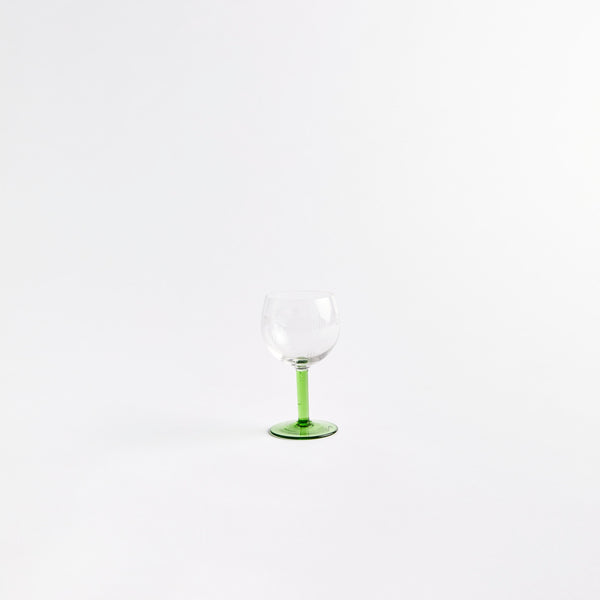 Clear wine glass with green stem.