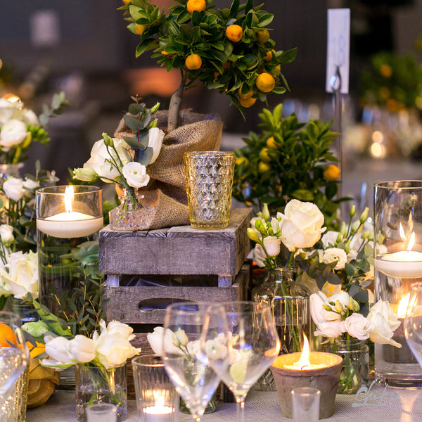 Table full of wine glasses, candles and flowers. 