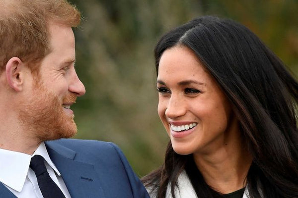 Photo of Prince Harry and Meghan Markle smiling at each other.