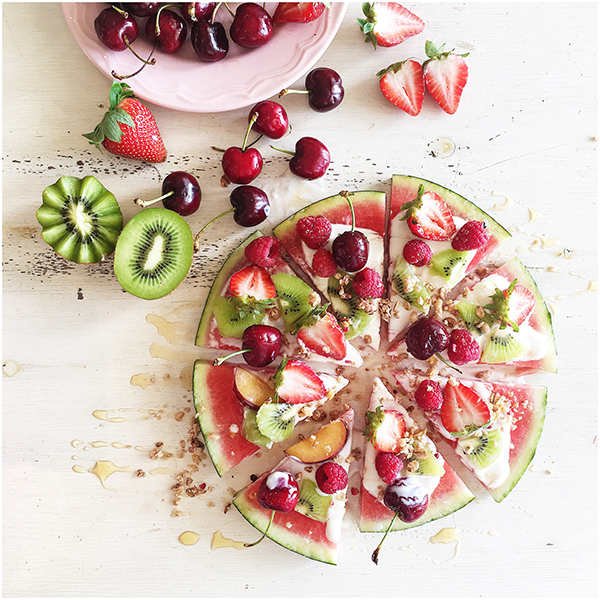 Watermelon pizza slices with yogurt and fruit toppings. 