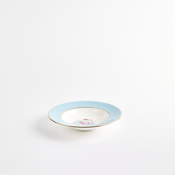 White bowl with blue rime and floral design interior.