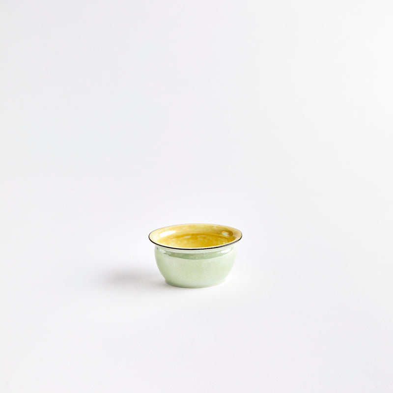 Green bowl with yellow interior. 
