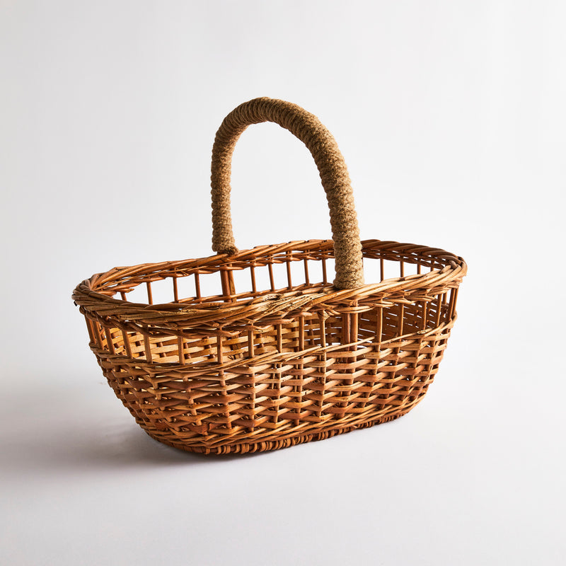 Brown wicker basket with rope handle.