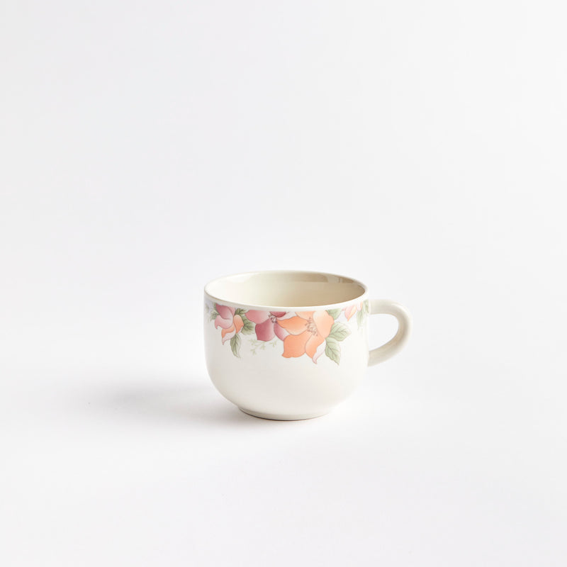 White coffee cup with pink and orange flowers.