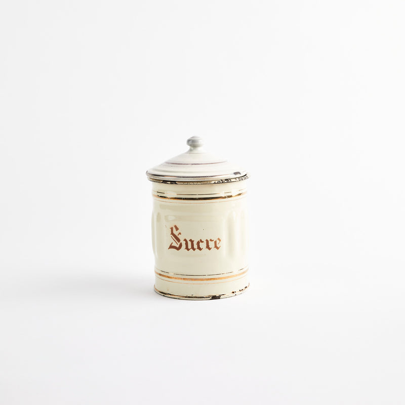 Cream container with gold detailing.