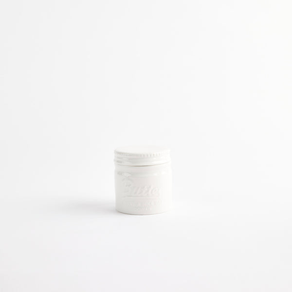 White ceramic container with embossed text.