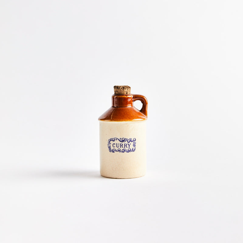 Beige and brown ceramic container with "Curry" in blue text.