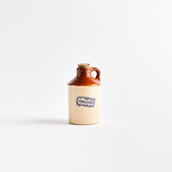 Beige and brown ceramic container with "Cinnamon" in blue text.