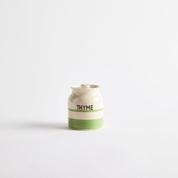 Cream with thin green stripes container with "THYME" in black lettering.