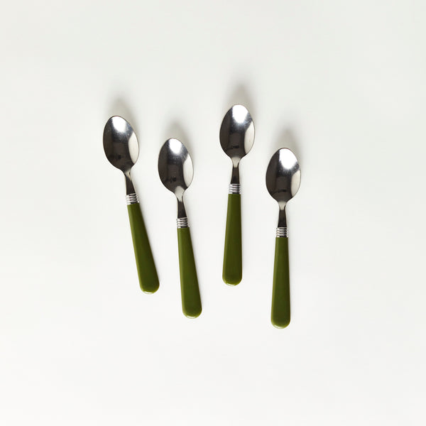 Four silver spoons with green handles.