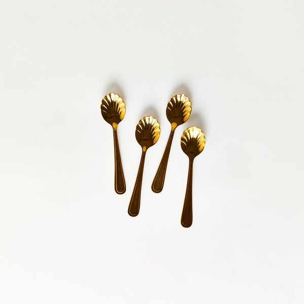 Four gold scalloped edge spoons.