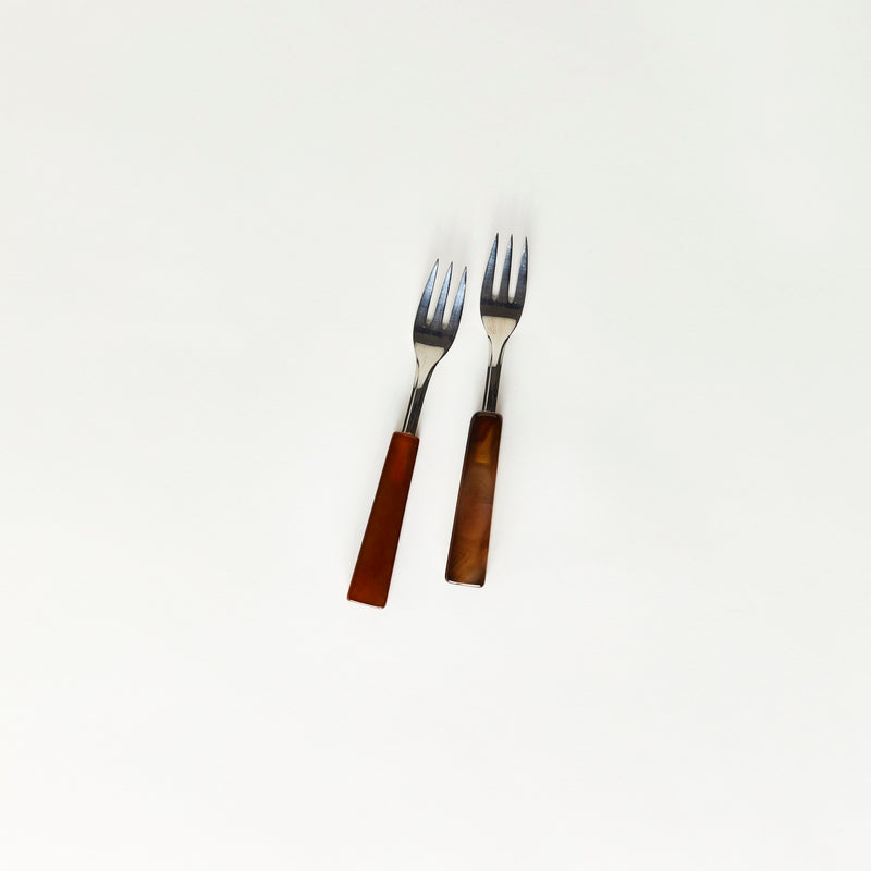 Two silver forks with brown handles.