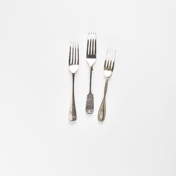 Three silver forks.