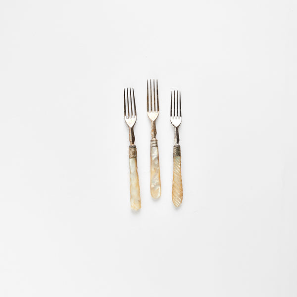 Three silver forks with pearl handle.