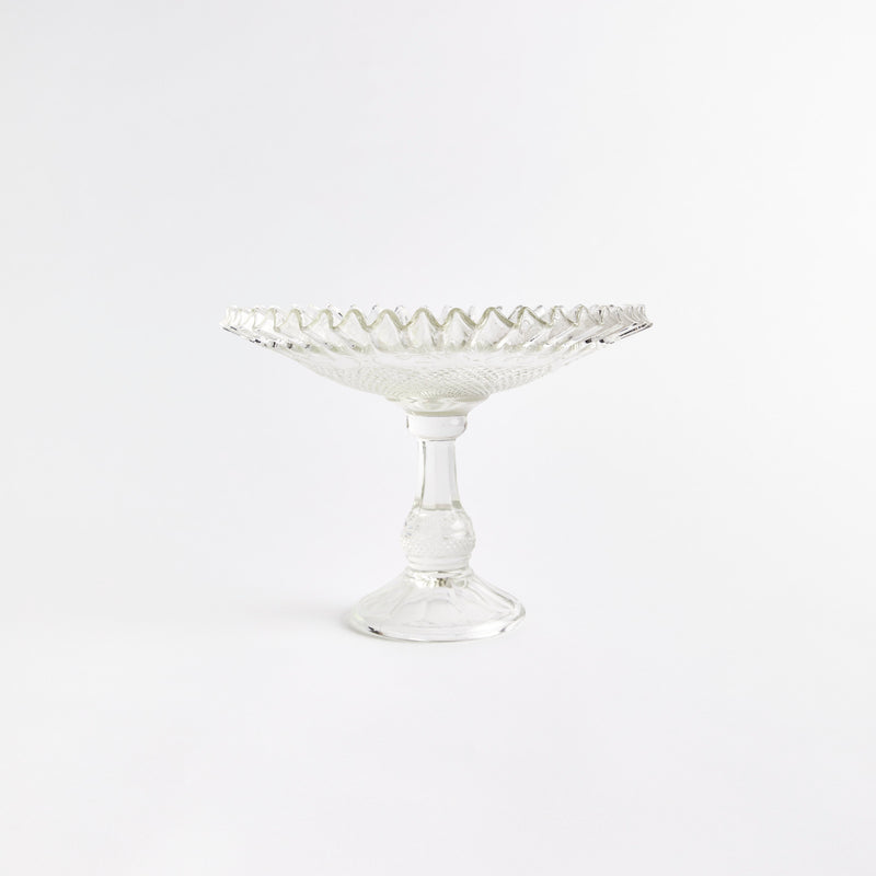 Clear glass display dish with embossed design and ruffled edge.