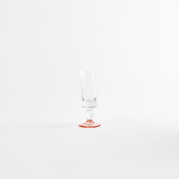 Clear floral etching glass cup with a orange base.