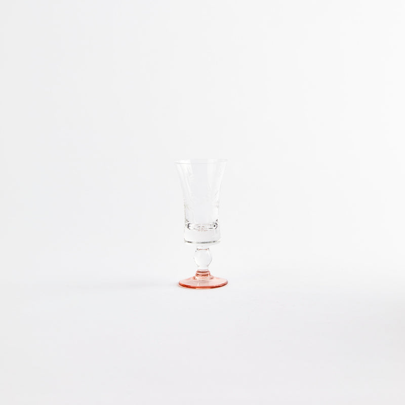 Clear floral etching glass cup with a orange base.