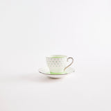 Green and white tea cup with saucer.