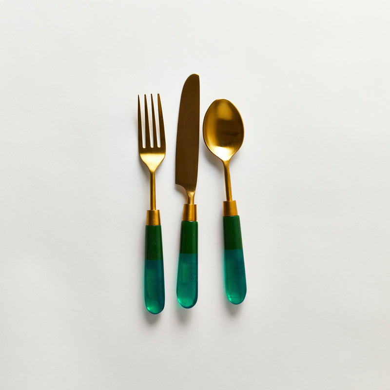 Gold serving cutlery with green handle.