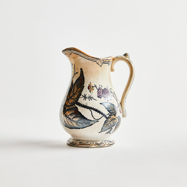 Cream jug with multicolour leaf design.