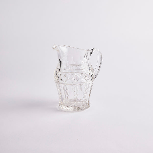 Clear glass jug with etched design.