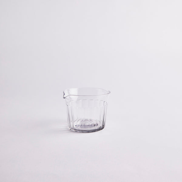 Small clear glass jug with ribbed design.