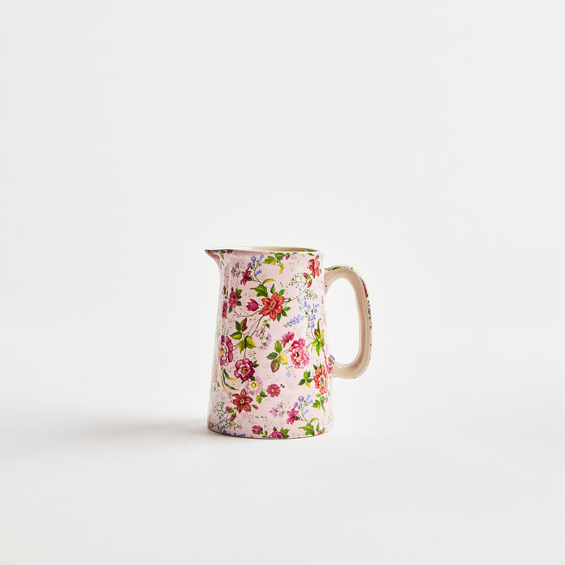 Pink ceramic jug with flowering detailing.