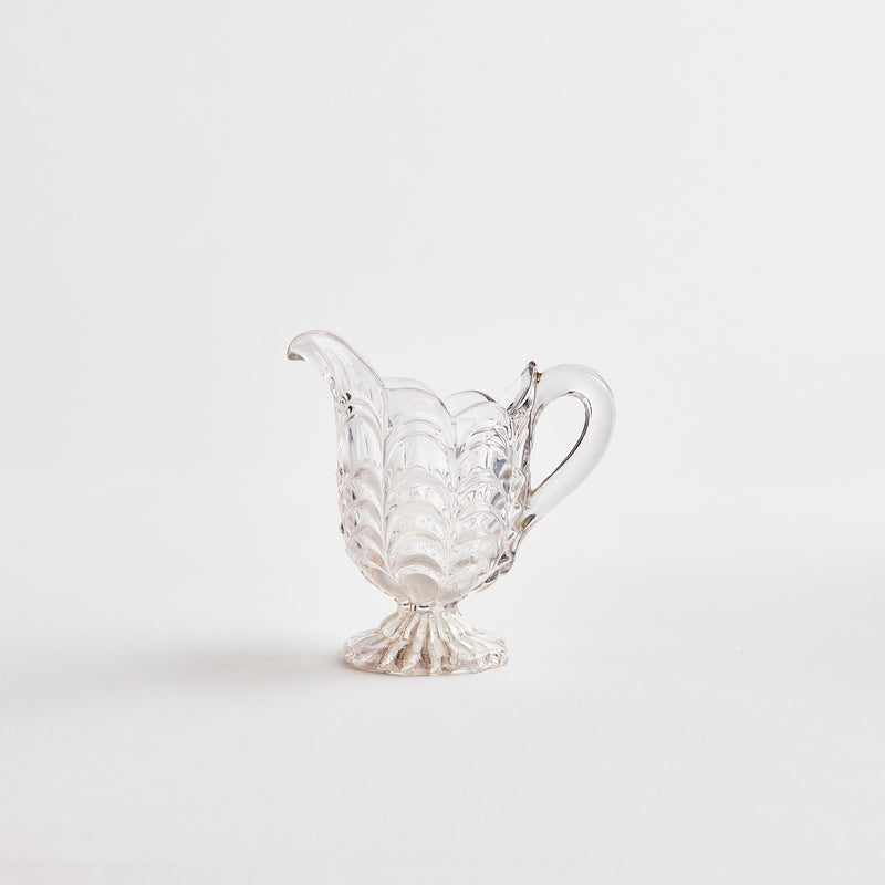 Clear glass jug with scallop detail.