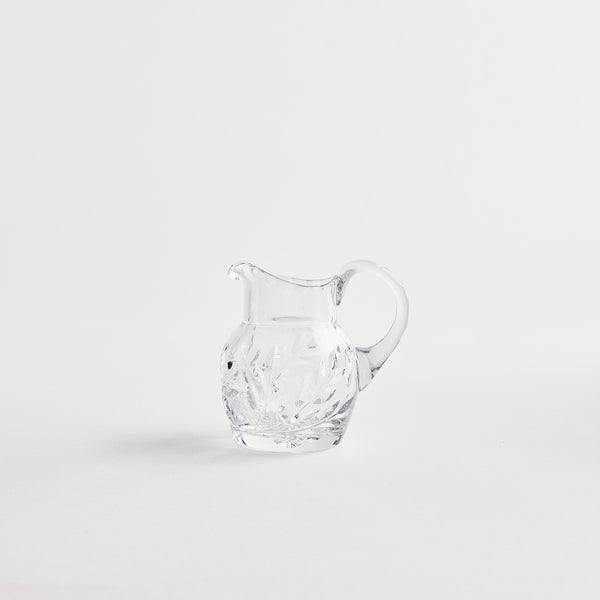 Clear glass jug with etched design.