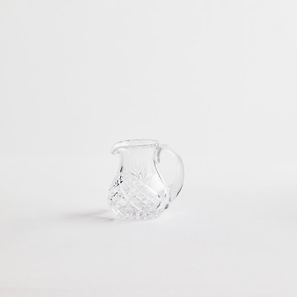 Clear glass jug with etched design.