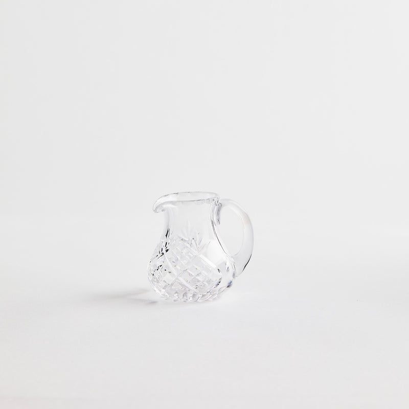 Clear glass jug with etched design.