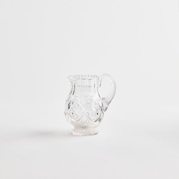 Clear glass jug with etched design.