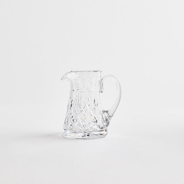 Clear glass jug with etched design.