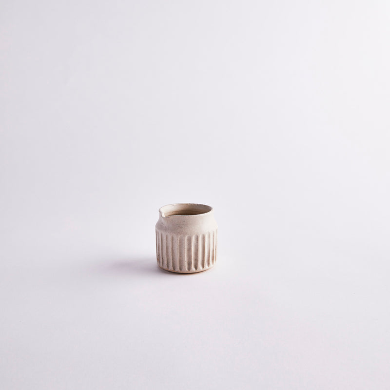 Cream ceramic jug with ripple design.