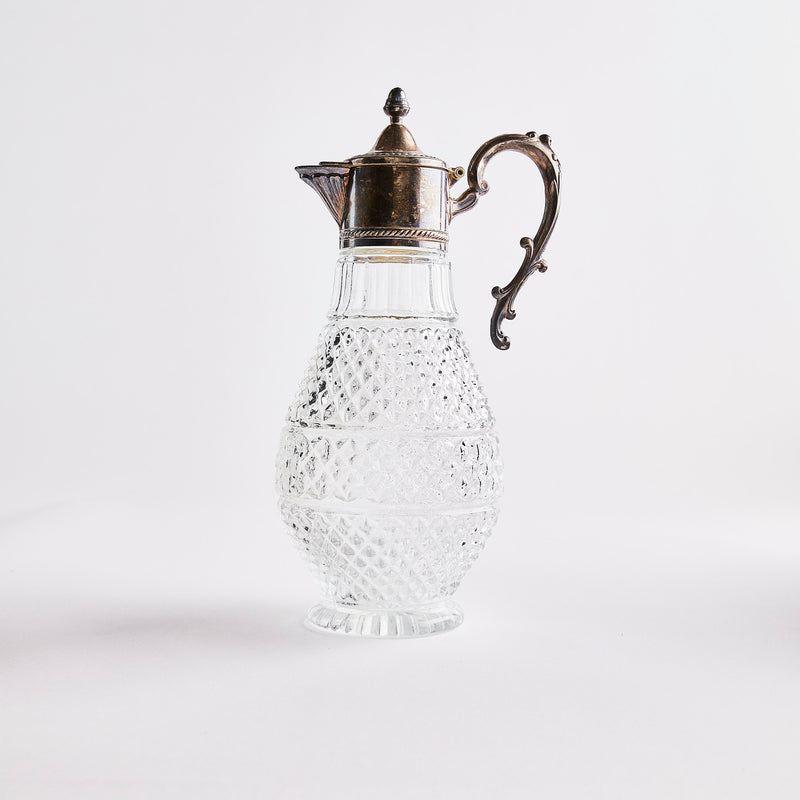 Clear glass jug with diamond embossed design with dark silver top.