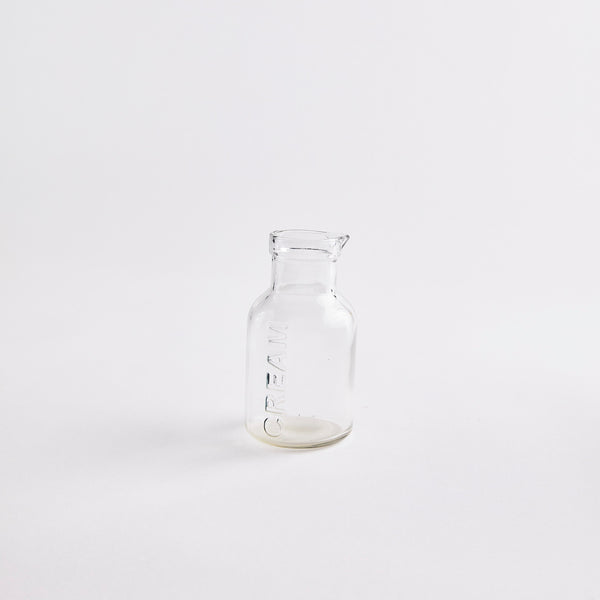 Clear glass jug with "CREAM" embossed.