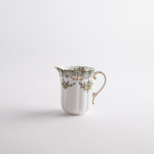 White jug with multicolour floral detailing.