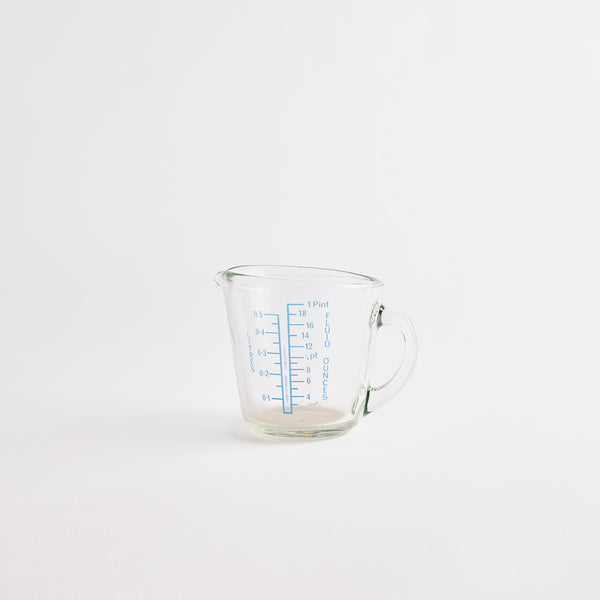 Clear measuring jug with blue text.