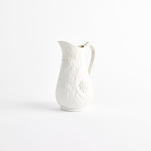 White porcelain jug with embossed fruit design.