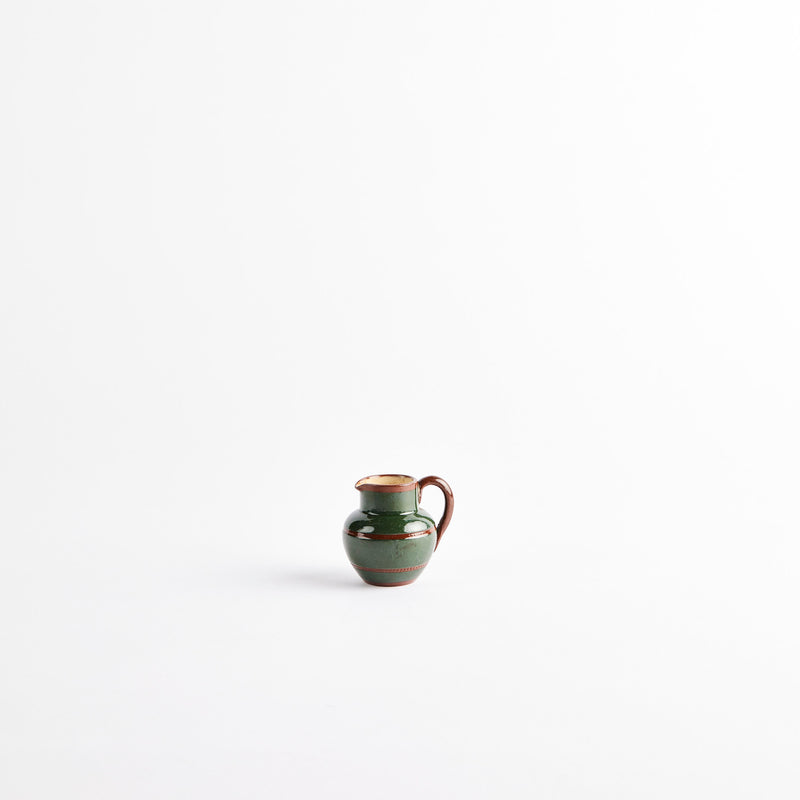 Green ceramic jug with brown detail.
