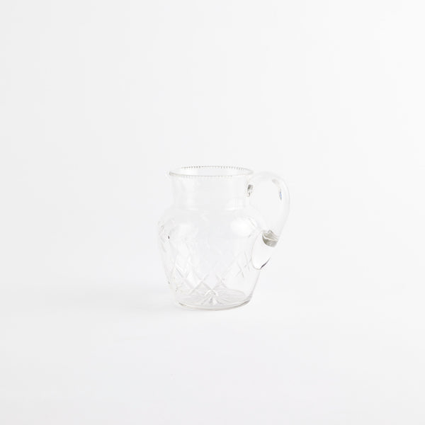 Clear glass jug with etched design.