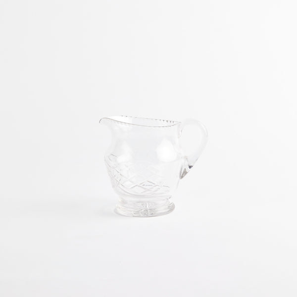 Clear glass jug with etched design.