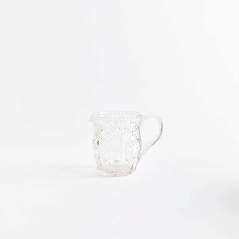 Clear glass jug with etched design.