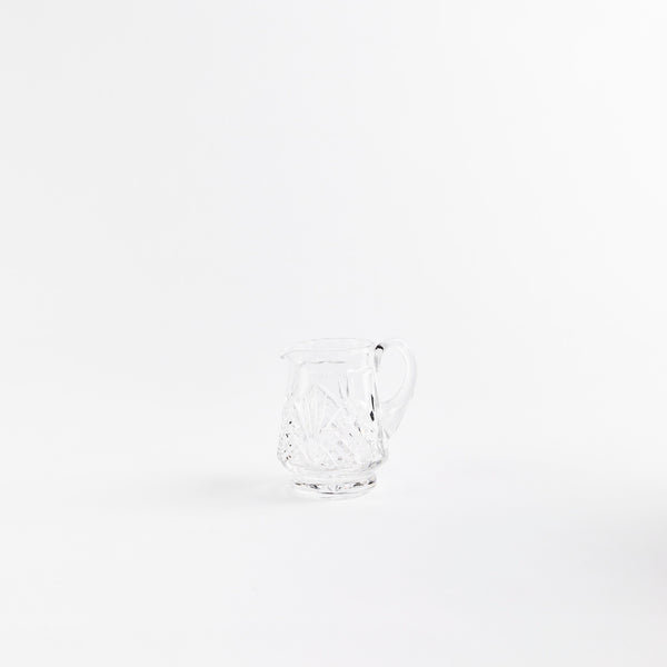 Clear glass jug with etched design.