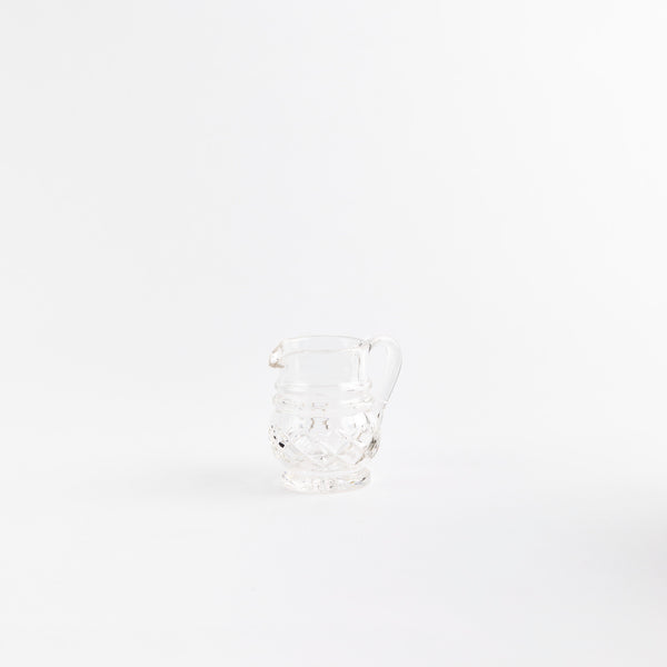 Clear glass jug with etched design.