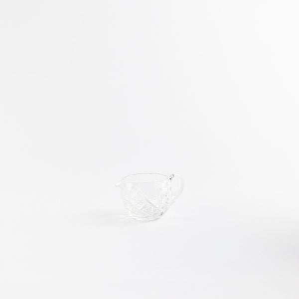 Clear glass jug with etched design.